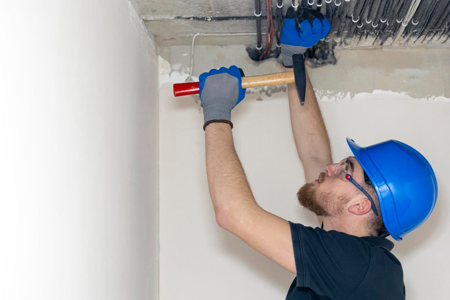 Electrician installing laying electrical cables on the ceiling inside the house